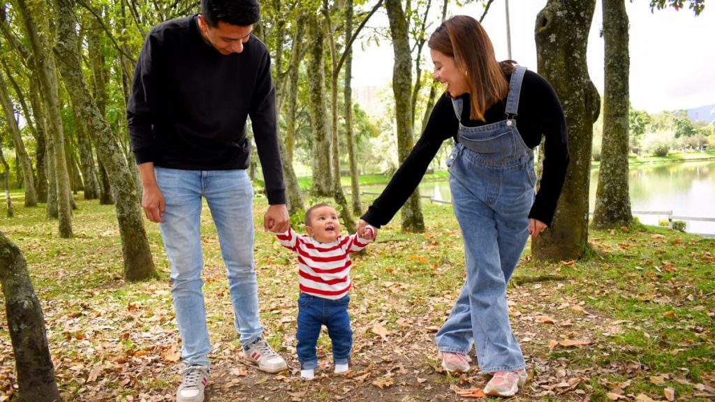 A joyful family enjoys a walk under lush green trees in the park.